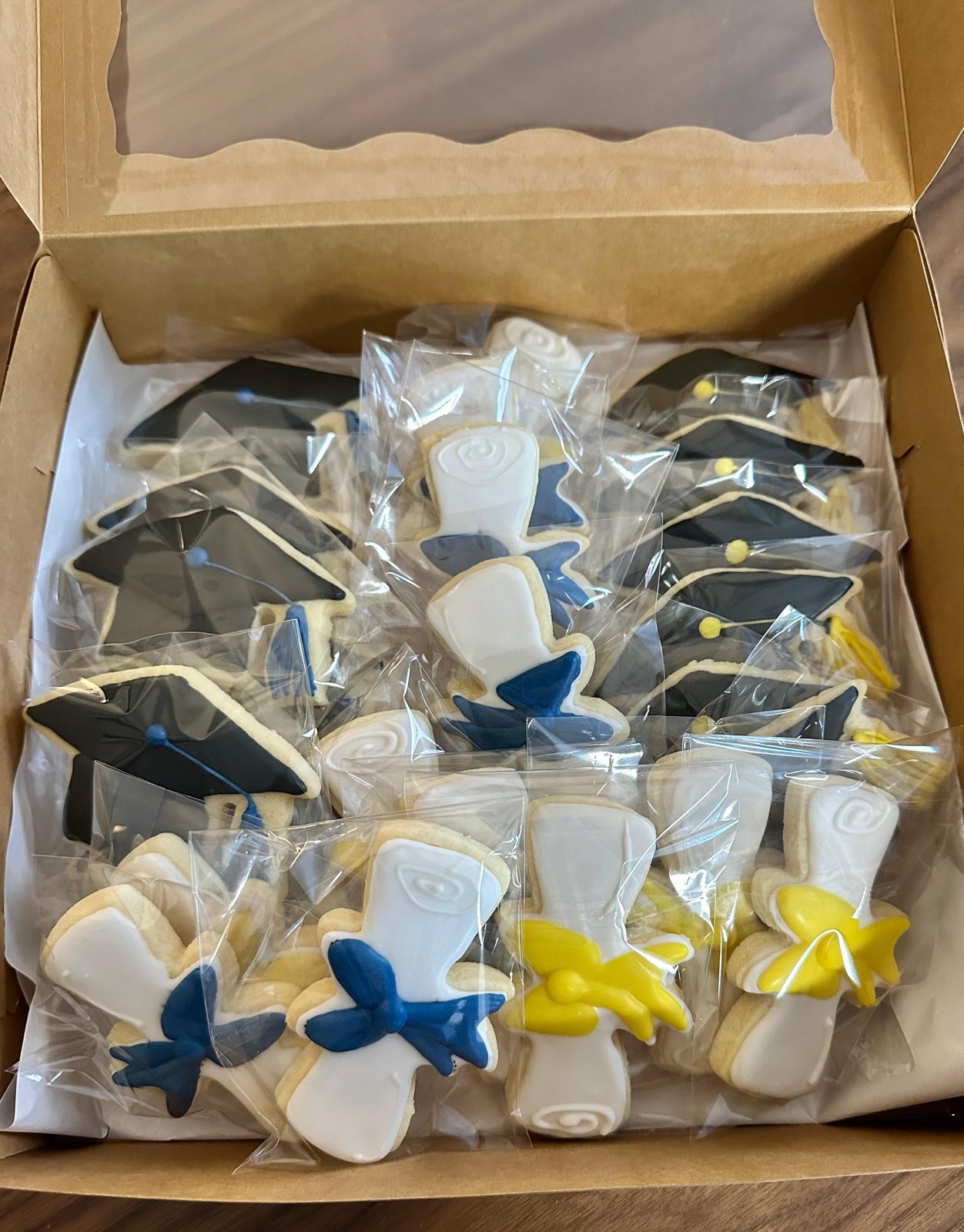 Graduation cap and diploma cookies packaged in a bakery box