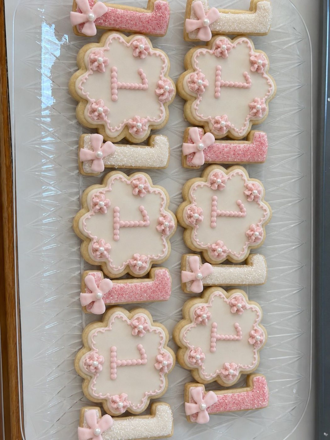 Pink and ivory floral monogram cookies with bows and pearl details
